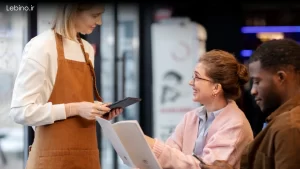 نرم افزار مدیریت ارتباط با مشتری CRM روی تبلت گارسون در رستوران شلوغ.